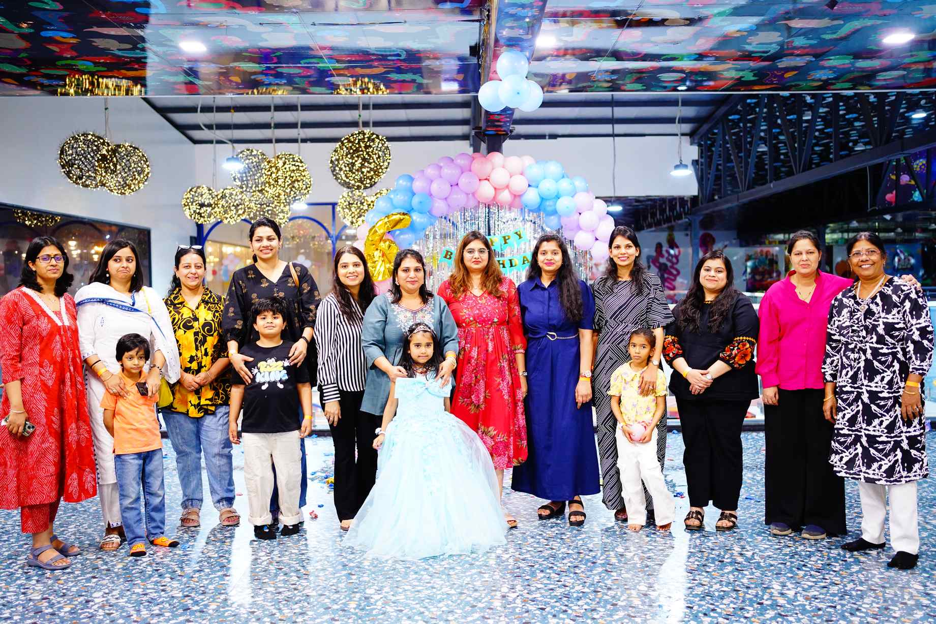 The whole family at the birthday venue, balloons and streamers behind them
