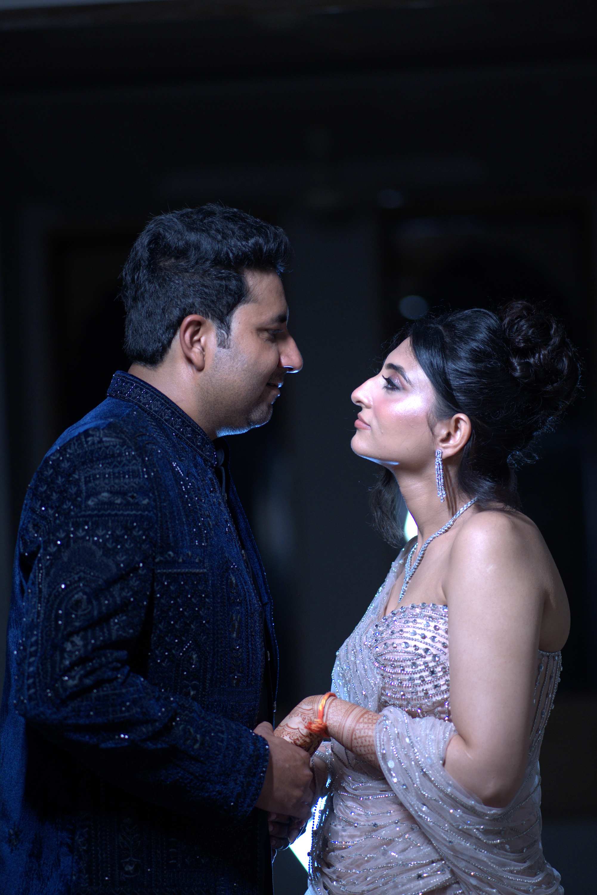 The couple facing each other, holding both hands